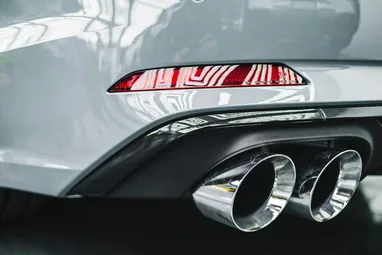 close-up van grijs lakwerk en glimmende chrome uitlaatpijpen na auto detail behandeling